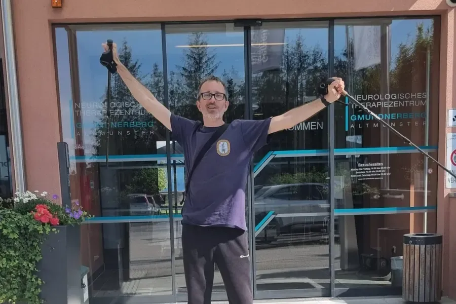 Marc steht vor der Rehaklinik – beim zweiten Aufenthalt, diesmal ohne Rollstuhl